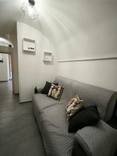 Una sala de estar con un sofá gris con almohadas. en da Nonna Maria, en Scicli