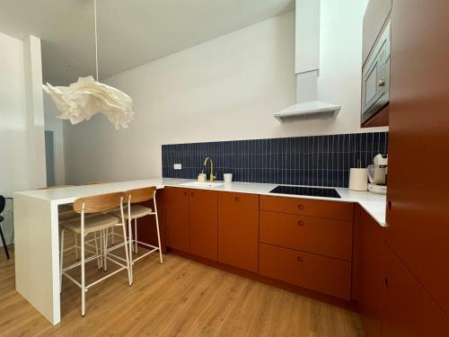 cocina con armarios naranjas y encimera blanca en Arroyo 3 Apartments, en Sevilla