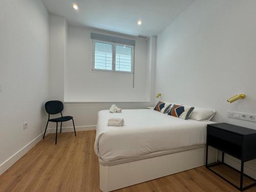 Habitación blanca con cama y ventana en Arroyo 3 Apartments, en Sevilla