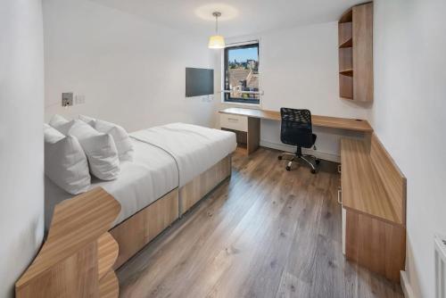 a bedroom with a bed and a desk with a computer at Modern Studios and Private Bedrooms with Shared Kitchen at Chapter Islington in London in London