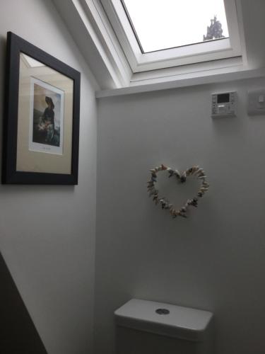 a heart on the wall above a toilet in a bathroom at Dwynant - A Room with a View in Llangathen