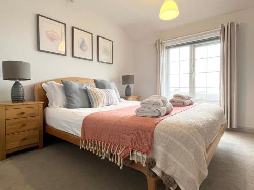 a bedroom with a bed with towels on it at Hebaska~Watergate Bay~3 Bedroom in Porth