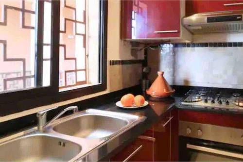 a kitchen with a sink and a stove and a window at Appart-Oasis Piscine et Terrasses in Marrakesh