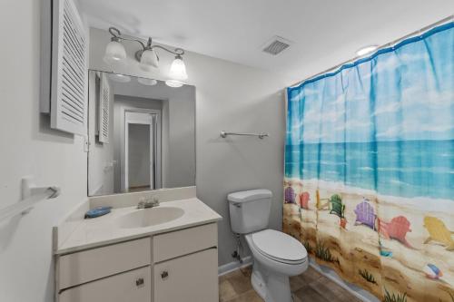 ein Badezimmer mit einem Waschbecken, einem WC und einem Duschvorhang in der Unterkunft Enjoy your vacation at the Triple Wave Rider in Virginia Beach