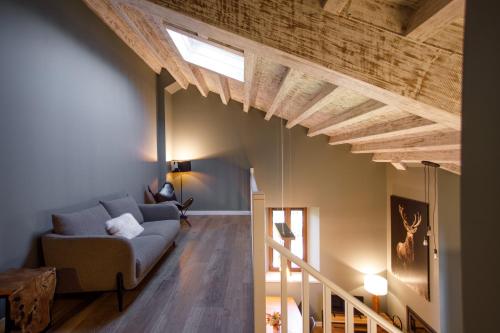 una sala de estar con sofá y techos de madera. en Mas d'Aravó - Casa Colonos, en Bolvir