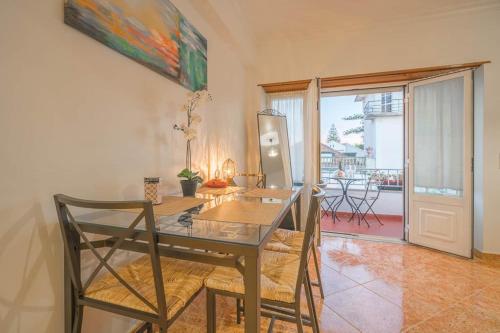 a dining room with a glass table and chairs at Sea View Wterrace 2 Mins From Beach In Old Town in Cascais