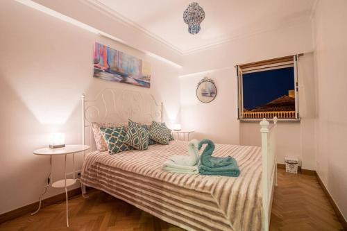 1 dormitorio con 2 toallas de cisne en una cama en Sea View Wterrace 2 Mins From Beach In Old Town en Cascais