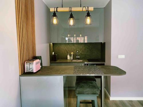 a kitchen with a table with a toaster and a sink at 150m To Beach-cosy Studiohistoric Oldtown in Cascais