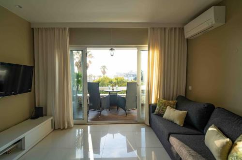 a living room with a couch and a table with chairs at Sea View W Balcony 2 Mins Walk To Beach & Casino in Estoril