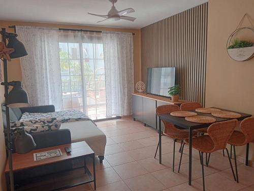 Schlafzimmer mit einem Bett, einem Tisch und Stühlen in der Unterkunft Greatly located apartment with heated pool, Los Cristianos in Los Cristianos
