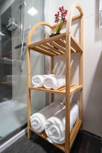 a wooden towel rack in a bathroom with towels at Sea View W Balcony 2 Mins Walk To Beach & Casino in Estoril
