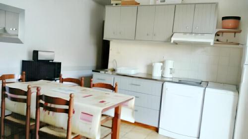 een keuken met een tafel en een koelkast bij Appartement de 2 chambres a Mimizan a 100 m de la plage avec terrasse amenagee in Mimizan