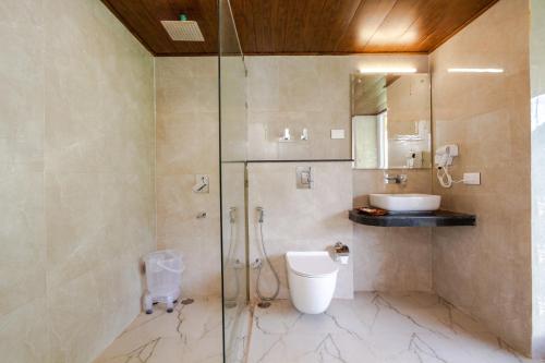 a bathroom with a shower and a toilet and a sink at Tripli Hotels Namaste Manali in Manāli
