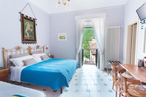 a bedroom with a blue bed and a table and chairs at Il Palazzo in Scanno