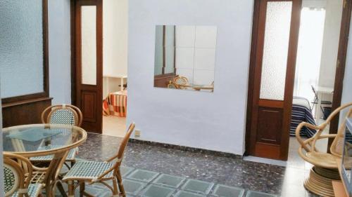uma sala de jantar com uma mesa de vidro e cadeiras em 3 bedrooms apartement with city view balcony and wifi at Cadiz em Cádiz