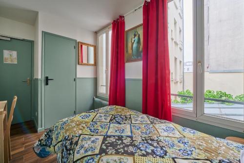 a bedroom with a bed and a window with red curtains at LE PADIRAC in Paris