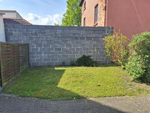 a retaining wall in a yard next to a house at Wohnung Sonnenschein Wolgast in Wolgast