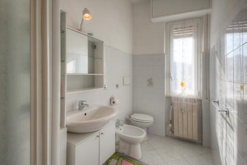 a white bathroom with a sink and a toilet at A Gonfie Vele VADOALMARE Immobiliare in Vado Ligure