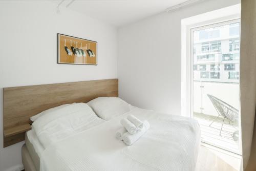 a white bed with two towels on top of it at Modern 2-bed apartment in Ørestaden in Copenhagen