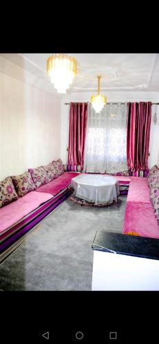 een woonkamer met roze banken en een tafel bij Airport apartment 2 