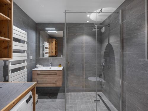 シャテルにあるLes Flambeaux - Apt B22 - BO Immobilier -Châtel - remises sur les forfaits de skis Châtel ou Portes du soleilのバスルーム(ガラス張りのシャワー、シンク付)