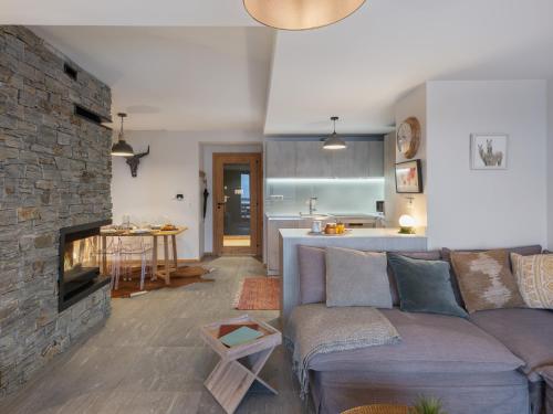 - un salon avec un canapé et une cheminée en pierre dans l'établissement Les Flambeaux - Apt B22 - BO Immobilier -Châtel - Multipass 2025 Été offert par votre hôte, à Châtel