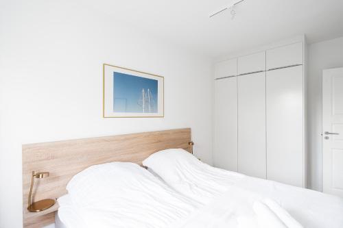 Refurbished 1-BR apartment in Charlottenlund - 208 في شارلوت لوند: غرفة نوم بيضاء مع سرير مع شراشف بيضاء