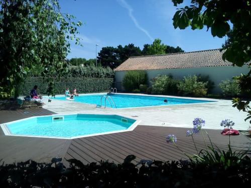 een zwembad in een achtertuin met een zwembad bij Appartement avec vue sur golf in Pornic
