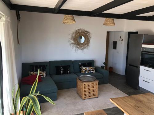 ein Wohnzimmer mit einem blauen Sofa und einem Tisch in der Unterkunft Villa Calderón Hondo in Lajares