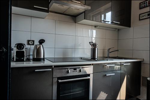 une cuisine avec un évier et une cuisinière four supérieur dans l'établissement Au kouglof avec Netflix, à Colmar