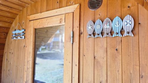 drzwi drewnianych domków z przyborami kuchennymi w obiekcie Rannamaja kümblustünni & saunaga w mieście Haapse