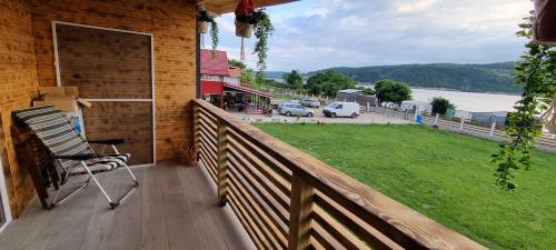 a balcony with a chair on a wooden fence at Casa Legrand in Baziaş