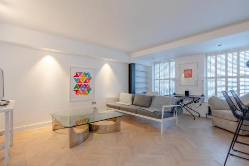 a living room with a couch and a table at Sleek & Stylish 2BD Flat - Warren Street in London