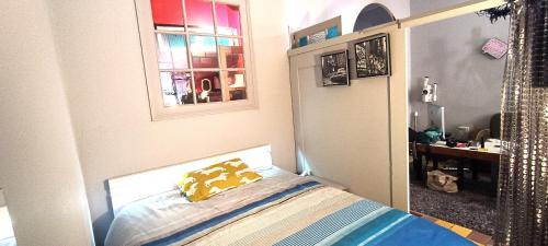 - une chambre avec un lit doté d'un oreiller jaune et d'un miroir dans l'établissement Un nid d amour au coeur de Séte, à Sète