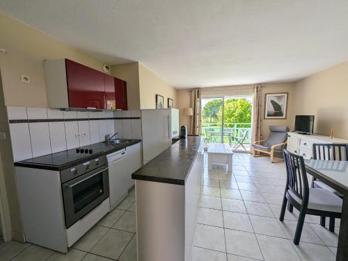 een keuken met witte apparatuur en een eetkamer bij Appartement avec vue sur golf in Pornic