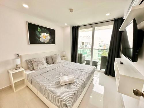 乔木提恩海滩Jungle View 1 BR in Amazon Residence的一间带床和大窗户的白色卧室