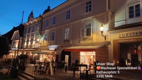 a building with tables and chairs in a street at night at Altstadthaus Marille mit Innenhofterrasse in Melk