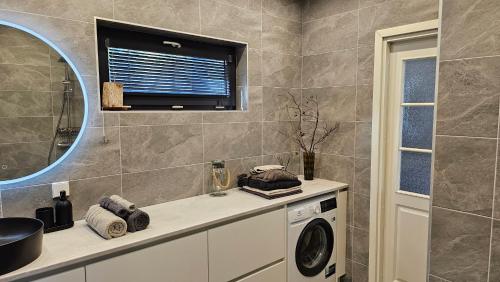 a bathroom with a washing machine and a window at Rannamaja kümblustünni & saunaga in Haapse