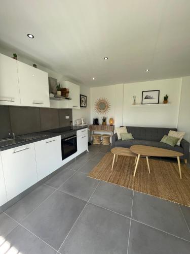 une cuisine et un salon avec une table et un canapé dans l'établissement Le beau studio du bord de l'eau, au Mans
