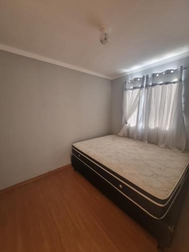 a small bedroom with a bed with a window at Apartamento araraquara in Araraquara