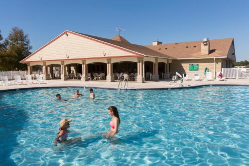 a group of people swimming in a swimming pool at Red Shoes RV Park and Chalets in Kinder