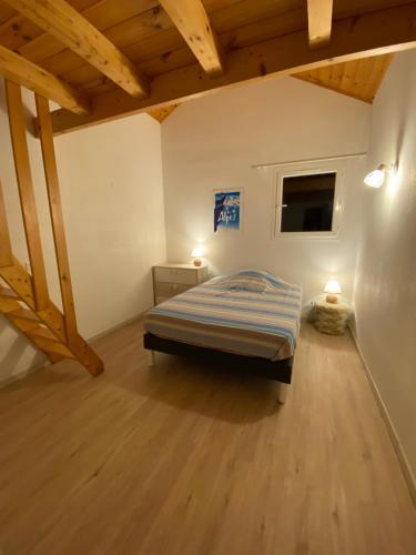 une chambre avec un lit dans une pièce avec des plafonds en bois dans l'établissement Grand appartement Ancelle, à Ancelle