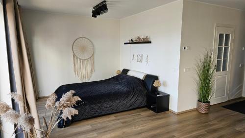 a bedroom with a bed with a black blanket at Rannamaja kümblustünni & saunaga in Haapse