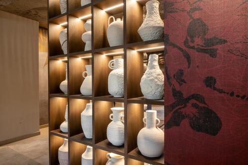 a display case with white vases on a wall at Hotel Ritual de Terra & SPA Moraira in Moraira
