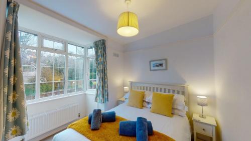 ein Schlafzimmer mit einem Bett mit gelben und blauen Kissen in der Unterkunft Kingfisher Cottage in Sidmouth