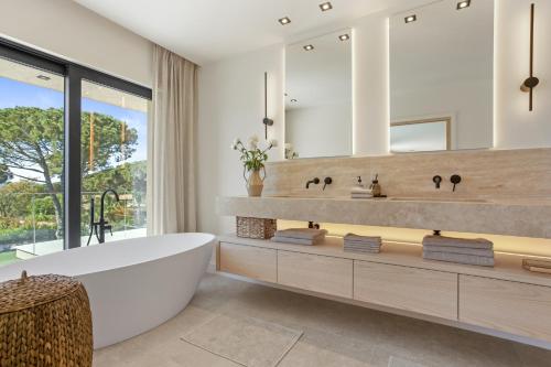 a bathroom with a tub and a large mirror at Villa 400m² Vue mer proche centre in Sainte-Maxime