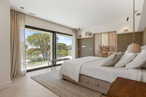a bedroom with a large bed and a large window at Villa 400m² Vue mer proche centre in Sainte-Maxime