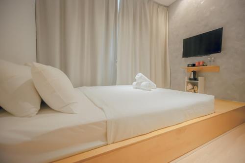 a white bed in a room with a television at Double H Boutique Hotel in Kuala Terengganu