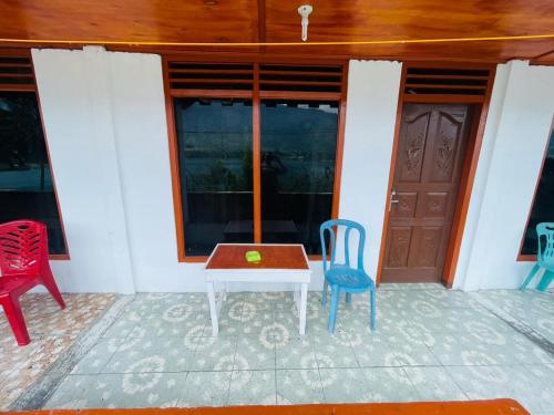 a patio with a table and two chairs and a door at Elsina guest house in Tuk Tuk