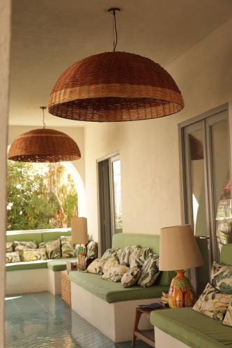 a living room with two couches and two large umbrellas at Hotel Terme Oriente - Beach & SPA in Ischia